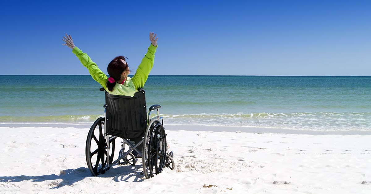 woman with a wheelchair on the beach