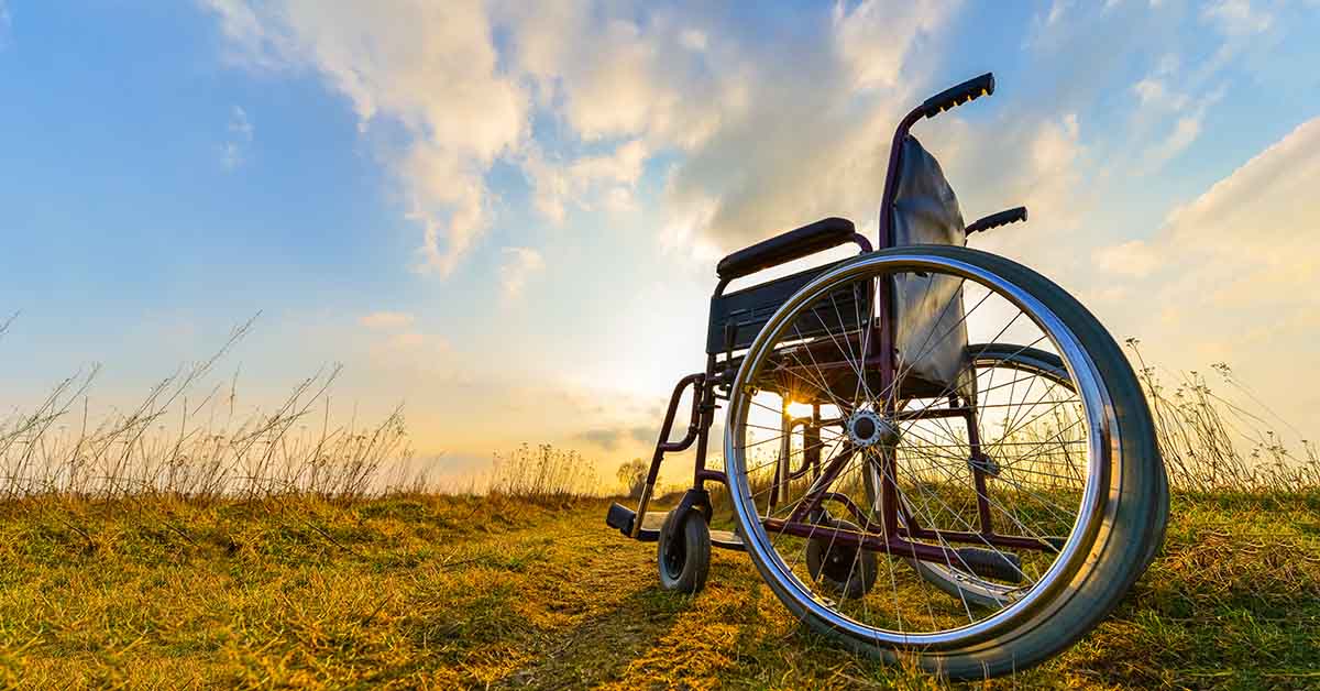 A used wheelchair on a field during sunset